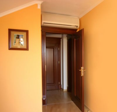 Кондиционер установленный на стене, нав дверью.